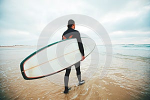 Surfer with surfboard goes to the ocean