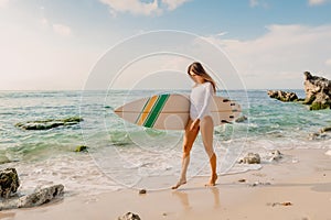 Surfer with surfboard going to ocean for surfing. Attractive surfer girl