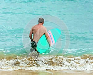 Surfer with surfboard in the ocean photo