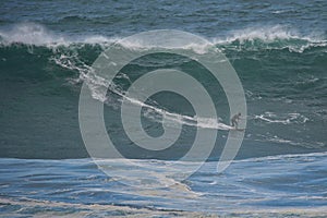 Surfer surfing on a big wave of the sea under the sunlight at daytime