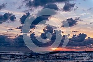 Surfer surfing at the vivid color of the North Sea sunset