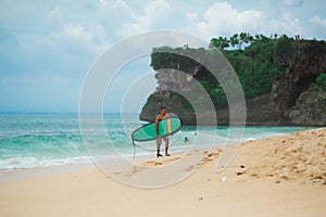 Surfer. Surfing Man With Surfboard Walking On Sandy tropical Beach. Healthy Lifestyle, water activities, Water Sport. Beautiful