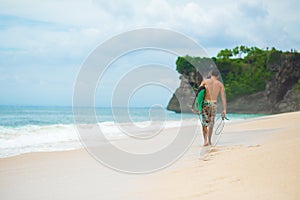 Surfer. Surfing Man With Surfboard Walking On Sandy tropical Beach. Healthy Lifestyle, water activities, Water Sport. Beautiful