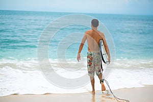 Surfer. Surfing Man With Surfboard Walking On Sandy tropical Beach. Healthy Lifestyle, water activities, Water Sport. Beautiful