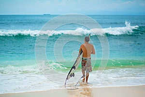 Surfer. Surfing Man With Surfboard Walking On Sandy tropical Beach. Healthy Lifestyle, water activities, Water Sport. Beautiful