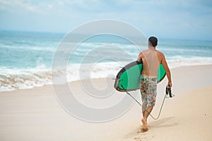 Surfer. Surfing Man With Surfboard Walking On Sandy tropical Beach. Healthy Lifestyle, water activities, Water Sport. Beautiful