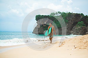 Surfer. Surfing Man With Surfboard Walking On Sandy tropical Beach. Healthy Lifestyle, water activities, Water Sport. Beautiful