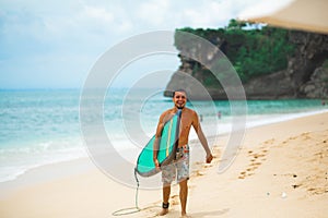 Surfer. Surfing Man With Surfboard Walking On Sandy tropical Beach. Healthy Lifestyle, water activities, Water Sport. Beautiful