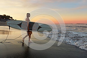 Surfer. Surfing Man With White Surfboard Walking On Sandy Beach. Water Sport For Active Lifestyle.
