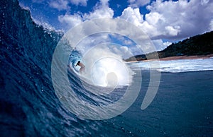 Surfer Surfing the Tube of a Blue Wave