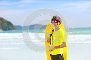 Surfer on tropical beach. Boy surfing