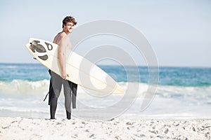 Surfer walking on the beach with a surfboard