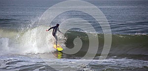 Surfer on wave at sandbar where the Santa Clara River empties into the Pacific Ocean at Ventura California U