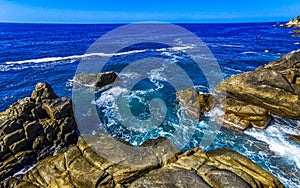 Surfer waves turquoise blue water rocks cliffs boulders Puerto Escondido