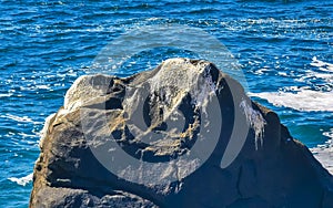 Surfer waves turquoise blue water rocks cliffs boulders Puerto Escondido