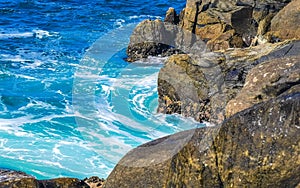 Surfer waves turquoise blue water rocks cliffs boulders Puerto Escondido