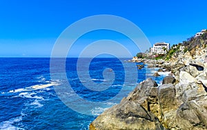 Surfer waves turquoise blue water rocks cliffs boulders Puerto Escondido