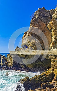 Surfer waves turquoise blue water rocks cliffs boulders Puerto Escondido