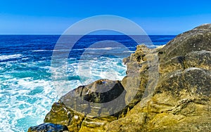 Surfer waves turquoise blue water rocks cliffs boulders Puerto Escondido