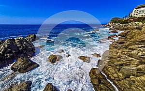 Surfer waves turquoise blue water rocks cliffs boulders Puerto Escondido