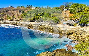 Surfer waves turquoise blue water rocks cliffs boulders Puerto Escondido