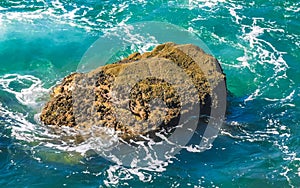 Surfer waves turquoise blue water rocks cliffs boulders Puerto Escondido