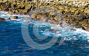 Surfer waves turquoise blue water rocks cliffs boulders Puerto Escondido