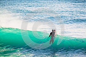 Surfer in wet suit and blue ocean wave. Surfing in blue ocean