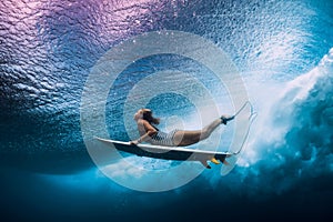 Surfer woman dive underwater. Surfgirl dive under wave