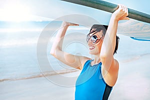 Surfer woman with longboard going into ocean waves. Active vacation concept image