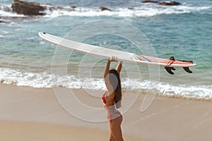 Surfer Woman with Surfboard in Tropical Paradise During Summer Sea Vacations