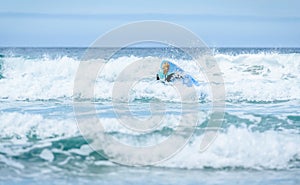 Surfer woman with surfboard is walking and watching the waves
