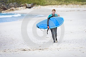 Surfer woman with surfboard is walking and watching the waves