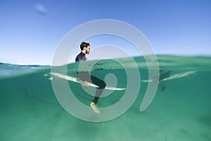 Surfers above and below waterline photo