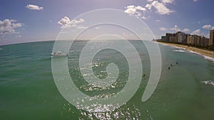 Surfers at Bal Harbour Miami 4k aerial video