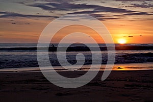 Surfers on the beach of Santa Teresa at sunset / Costa Rica