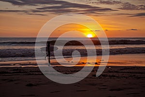 Surfers on the beach of Santa Teresa at sunset / Costa Rica