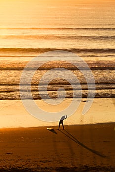 Surfers on beach at sunset