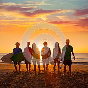 Surfers boys and girls group walking on beach