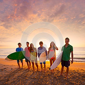 Surfers boys and girls group walking on beach