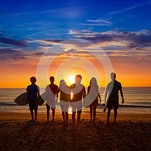 Surfers boys and girls group walking on beach