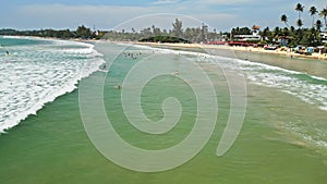 Surfers catch waves in tropical surf spot showcasing skill, coordination, beach life, travel destination for watersport