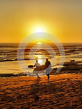 Surfers Coming in at Sunset