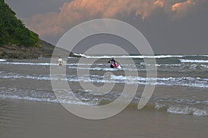Surfers entering the water in the mornnig carrying their boards