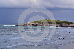 Surfers at Fistral beach bay in Newquay at a cloudy day