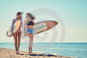 Surfers girls on beach having fun in summer Vacation. Extreme Sp