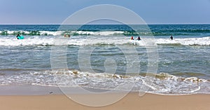 Surfers going to surf, ocean sea waves in a sunny spring day