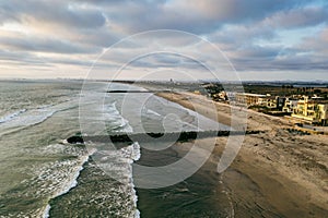 Surfers in ocean by jetty in Imperial Beach San Diego California, aerial shot.