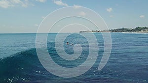 Surfers in the ocean, male surfer catches and ride a massive barreling waves.