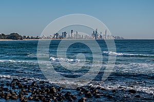 Surfers Paradise with rocky beach in the foreground.